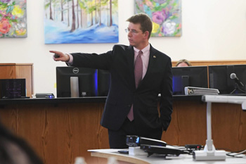 Deputy Chief Assistant Attorney General John Darnall stands pointing in a courtroom