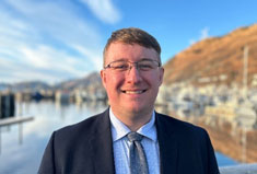 William Vitkus, Kodiak DA, stands in front of the port on a clear fall day.